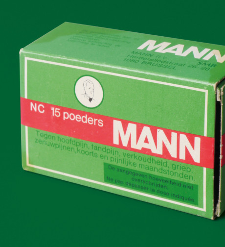 448399-Verpakking voor poeder van het merk Mann, gebruikt tegen hoofdpijn, tandpijn, verkoudheid, griep, zenuwpijnen, koorts en pijnlijke maandstonden. Veel fabrieksarbeiders namen deze poeders, of een v-b3bffb-